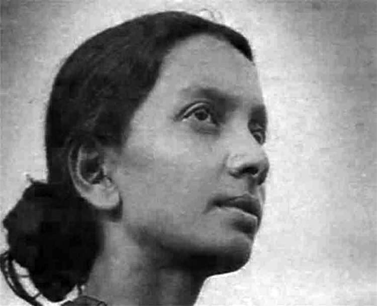 Archival photograph of a young Kalpana Datta in three-quarter profile, looking upward and to her right against a plain background.